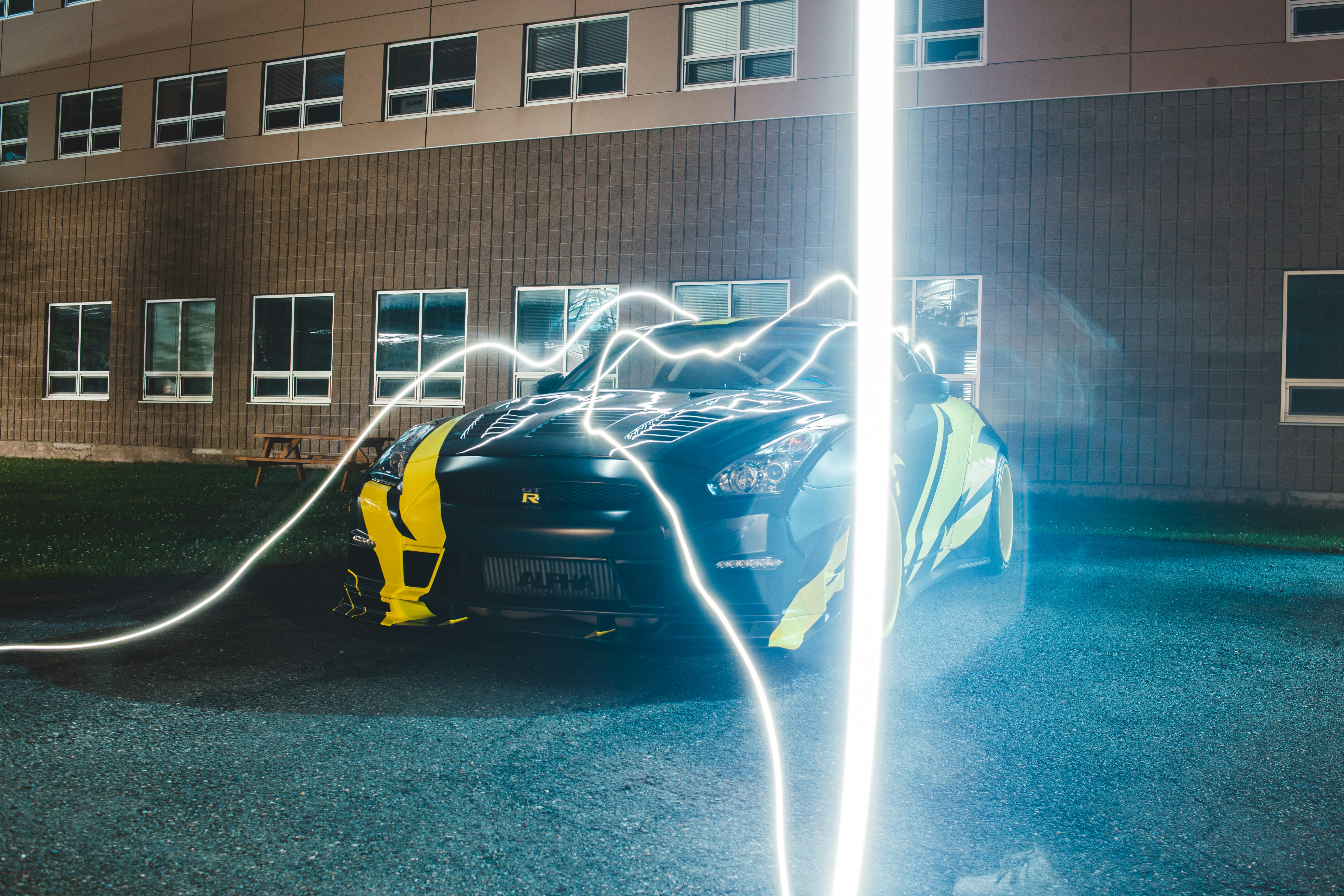 man in blue shirt and black pants standing beside yellow car